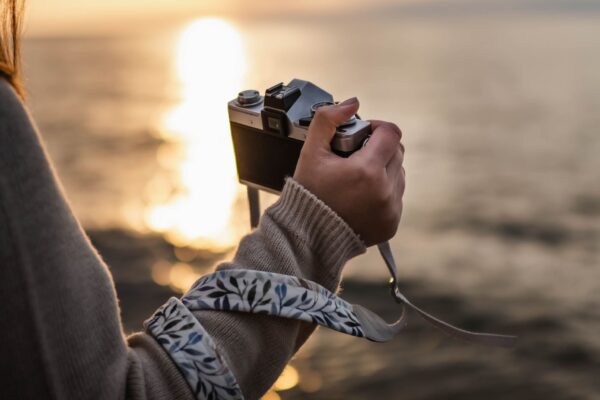 A photo of a strap wrapped around the hand with a sunset background